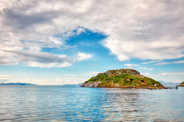 Touristic rabbit island, calm sea, sky and clouds in Bodrum, Gumusluk, Mugla, Turkey