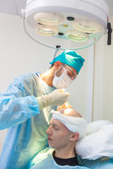 The surgeon gives injections to the head. Baldness treatment. Hair transplant. Surgeons in the...