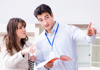 Fototapeta premium Salesman explaining to woman customer at furniture store