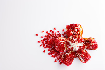 Pomegranate fruit with seeds on a white background. A glass of pomegranate juice