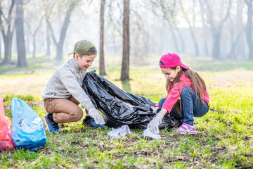 Kids scavenge trash in the spring park. Volunteer and ecology concept