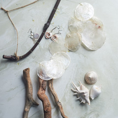 Sea collection on grey marble background.Seashell and mother-of-pearl earrings. Summer jewelry.