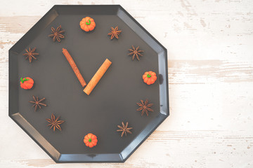 autumn fall flat lay, top view arrangement, clock made of natural materials pumpkin, cinnamon sticks, walnuts, star anise on white background, flat lay, top view