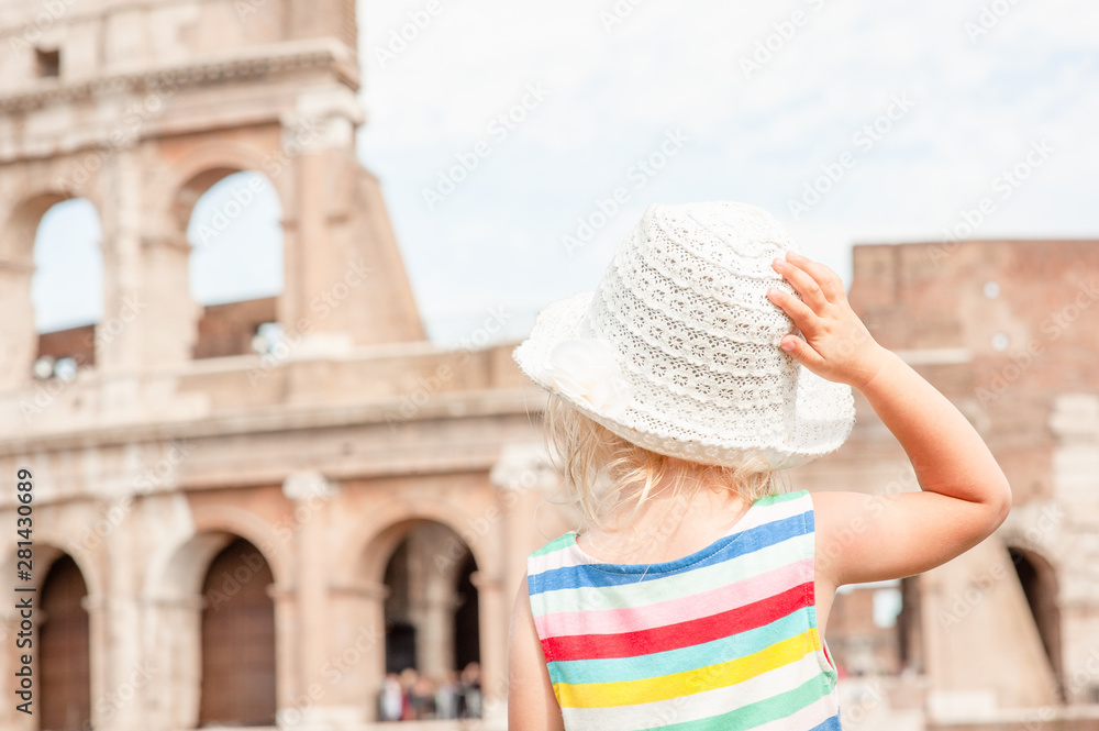 Wall mural little girl enjoying the view of the coliseum in rome, italy. back view