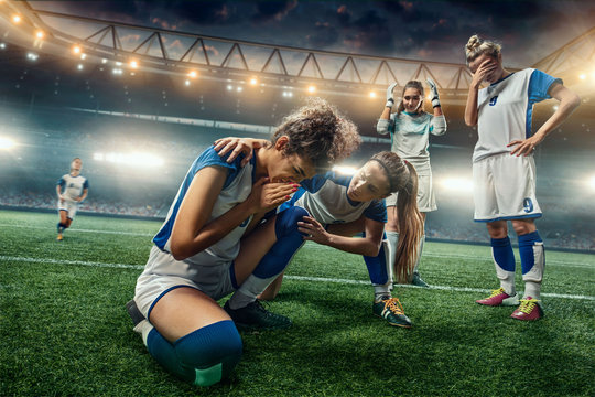 Sad Female Soccer players on a professional soccer stadium. Girls Team crying