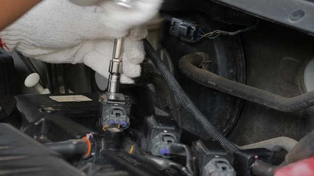 Close up shot mechanic hands are spinning bolt of car to fix and repair the car
