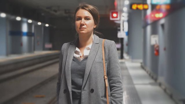 Woman is waiting for the train in subway station.