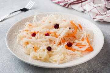 Homemade sauerkraut with carrots and cranberries in plate.