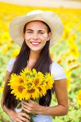 Portrait of a young beautiful girl in a field of sunflowers