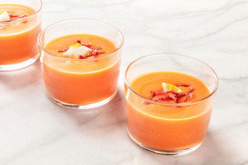Salmorejo, Spanish cold tomato and bread soup, in glasses on a marble background with a place for text