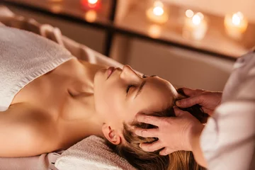 Die Hände der Masseurin machen einer schönen Kundenfrau eine manuelle Massage des Kopfes. Konzept der Kopfhautbehandlung und Haarwachstumsstimulation