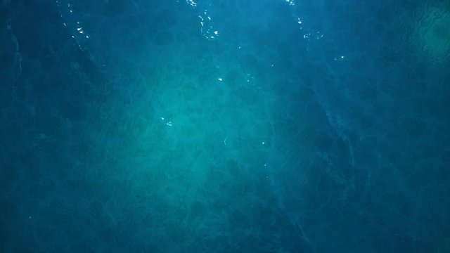 Sea or ocean, waves close-up view. Blue waves sea water. Blue crystal clear water. One can see the sandy seabed. Sea waves top view. 3D 4K animation