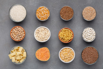 Set of healthy grains and noodles full of carbohydrates on gray