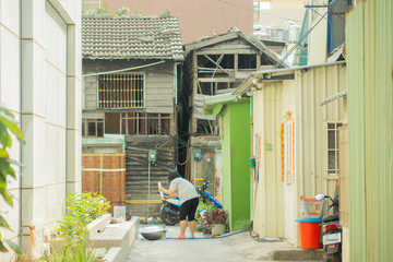 Kaohsiung/Taiwan-18.05.2018:The poor district in Kaohsiung city. Woman washing their closes on the street