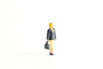 Miniature Businesswomen holding a bag standing on a White Isolated Background