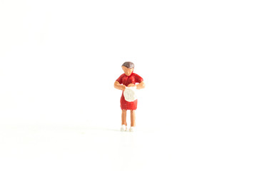 Miniature person (old lady) looking through a bag standing on a White Isolated Background