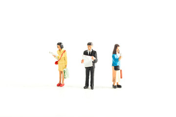 Obraz premium Miniature People Looking at Media/Newspaper/Phone Standing on a White Isolated Background