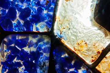 Colored glass mosaic close-up with sunlight passing through. Abstract background