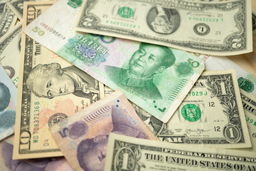 Select focus of 10 US dollar stack under China yuan banknote. Concept of Trade war between the United States and China.