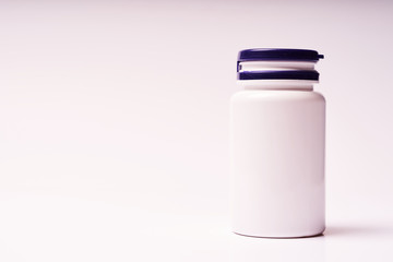 White bottle with blue lid for vitamins on white background