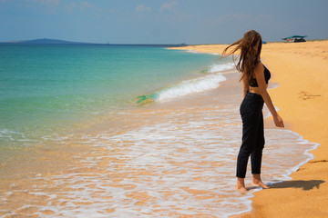 Early morning. Young attractive girl running around the beach.