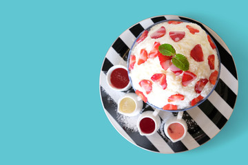 Strawberry Bingsu ice cream Korean dessert on cyan background.