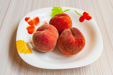 ripe fruit peaches three pieces on a plate, in a Cup, in a bowl
