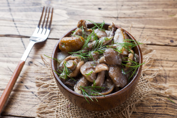 Stewed mushrooms in a sauce with sour cream and cheese in a wooden bowl.