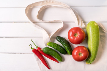 Fresh vegetables in eco Reusable zero waste textile shopping bag over white background, horizontal orientation.