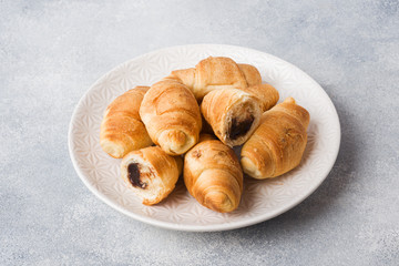 Croissants with chocolate filling on a plate gray background. Copy space.