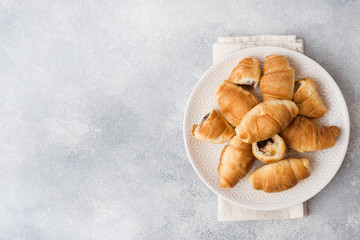 Croissants with chocolate filling on a plate gray background. Copy space.