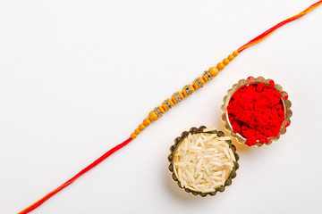 Indian festival Raksha Bandhan , Rakhi with rice grains, kumkum on Decorative plate , A traditional Indian wrist band which is a symbol of love between Brothers and Sisters