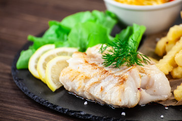Fish dish - fried fish fillet with french fries and vegetables