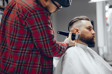 Man with a beard. Hairdresser with a client. Man in a red shirt