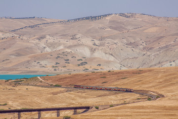 Passenger train in the desert, near a lake