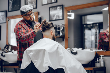Man with a beard. Hairdresser with a client. Man in a red shirt