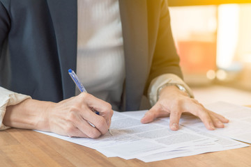 Businesswoman writing on paper in her office