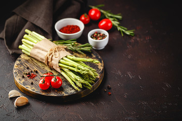 Asparagus and tomatoes on rusticbackground