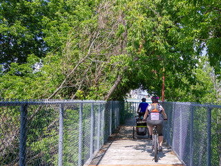 family on a wooden bike trail across the river in Quebec