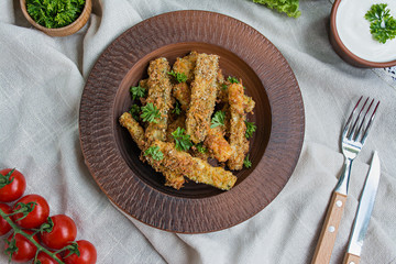 Baked zucchini with cheese and breadcrumbs. Vegan food. Vegetarian cuisine. View from above. Light background.