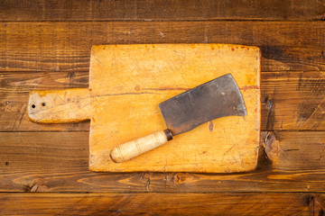 cutting board with old kitchen knifes in wooden background