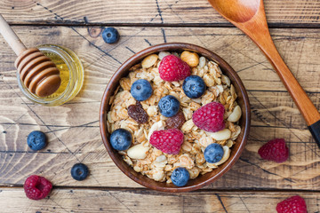 Healthy breakfast. Fresh granola, muesli with yogurt and berries on wooden background. Copy space.