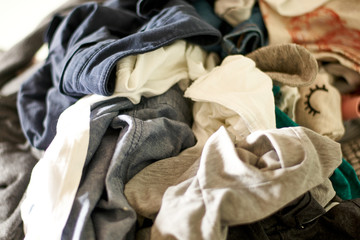 Close up on a big pile of clothes and accessories thrown on the ground. Untidy cluttered