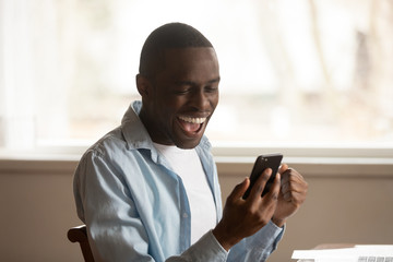 African guy look at cellphone read great news feels happy