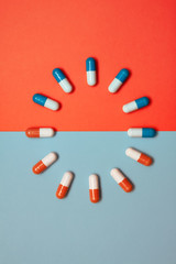 Blue and orange vitamins on colored background