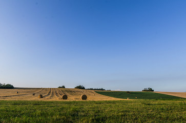 Fototapeta na wymiar Landscape photo with blue sky, mowed field and hay bales