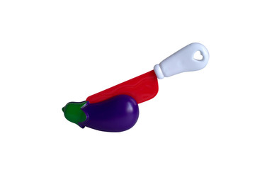 Red knife cuts purple eggplant. Cut the vegetable in half.