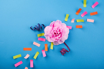 Pink flower with color papers on the blue background