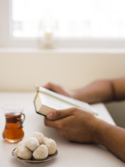 Close up praying holding opened quran