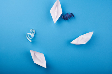 White paper ships on the blue background